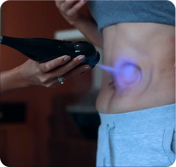 Handheld cryotherapy device used on the side of the abdomen