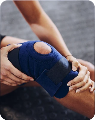 Person holding their knee in a support brace after exercise